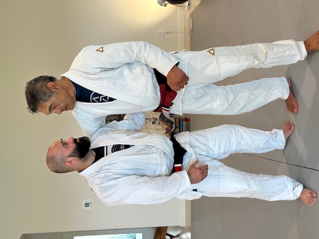 1st Degree from Chris Burns. I owe a lot ot Chris. He helped me refine all of my technique, and showed me details I was missing.  He helped me understand the concepts and principles behind Rickson's Jiu Jitsu, and also how Rickson's Jiu Jitsu has evolved from when he ran an academy with Henry Akins to now. Chris gave me hours upon hours of instruction and fine tuning.  He tested me for my 1st degree over the course of 3 years, and for the final stage of the test, I went with him on tour and was tested for 2.5 weeks straight, including being tested at Rickson's house.  I am honored and humbled to be ranked under Chris, and am forever grateful.  I look forward to continuing to learn from Chris and respresent him. It is an honor to be part of this journey. - Photo 4